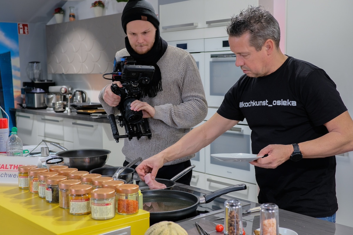 Filmemacher Oliver Weisskopf mit Kunde Volker Osieka von Osieka Kochkunstbeim Dreh am Herd.